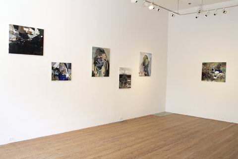 Installation image of two walls. On the left wall is five abstract images and on the right wall is one abstract image. The five images in a row feature dark colors and are placed in a staggered line, alternating from high and low placement. 