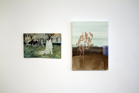 Up-close installation image of two works. On the left is a small painting featuring a green-ish background of foliage. The style of the painting is similar to impressionism. Two figures, pictured as white shapes, are in the middle of the painting. On the right is a painting of a field. The dark brown grass meets the light blue sky in the distance on the horizon line. 