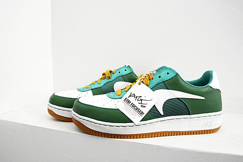 Side view of green sneakers with yellow laces. A tag hanging off the laces says "stay focused." 