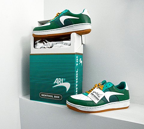 One green sneaker is placed on top of a green box that resembles a Menthol Cigarette case. The other green sneaker is placed to the right side of the box. 