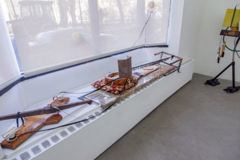 Installation view of the exhibition featuring several mechanisms of wood, rope, and various materials. 
