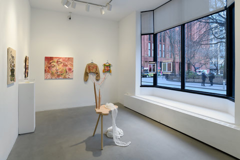 Installation view of the entire exhibition room include two walls, four window panes that look out onto the street, and a sculpture in the center of the room. 