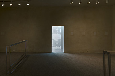 A large room with stained yellow walls and bare metal structures.