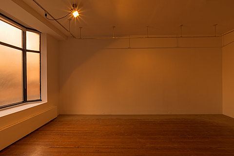 A room with white walls is lit by a warm sodium light.