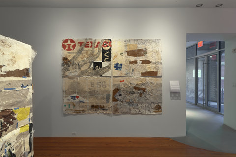 Image of one work hanging against a white wall in the exhibition space. The work consists of mangled and re-arranged bits of canvas. 