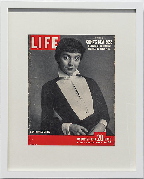 A framed cover of a 1950's LIFE magazine showing a woman wearing a tuxedo shirt.