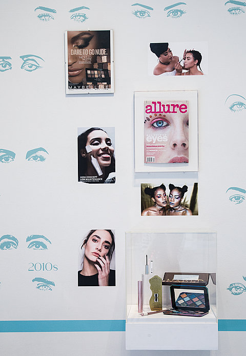 A series of framed prints of makeup advertisements from the 2010's.