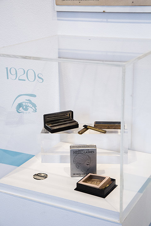 A display case holding 1920's eye makeup, including false lashes.