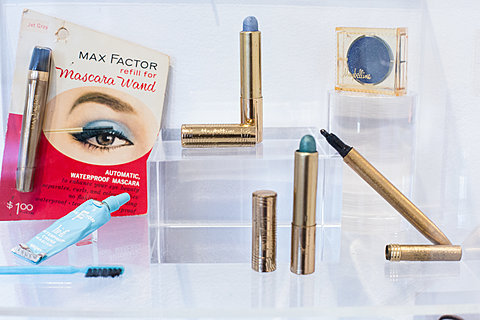 A display case holding vintage mascara wands and eye-shadow pens.