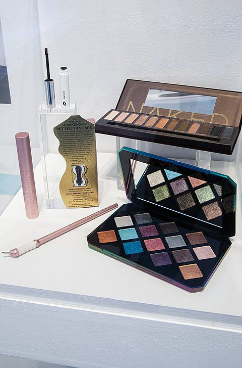 Two compact makeup palettes from the 2010's sit in a display case.