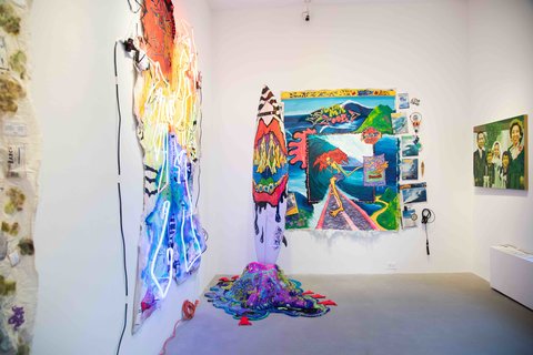 Installation view of the exhibition featuring an array of multi-colored and vibrant artworks. 