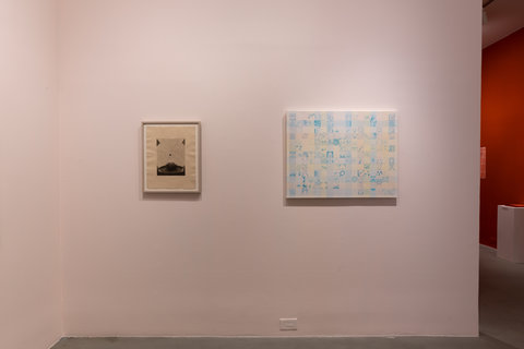 Installation view of two works against a light pink wall. The first work is smaller than the second. The work on the left features a framed sketch of muted tones. On the right is a blue and light pink checkerboard of sketches. Each square of the checkerboard features a sketch or small image of an item, though it is tough to make out from the camera angle.  