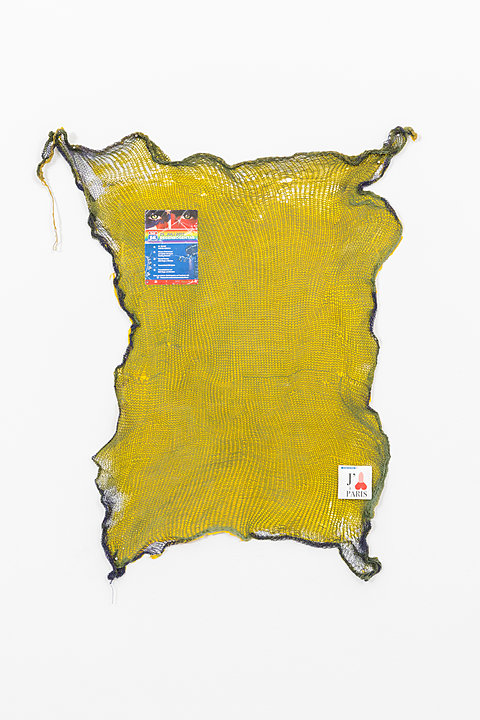 A large hanging yellow mesh sheet with two pieces of paper attached to it.
