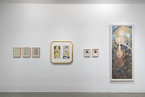 Multiple framed drawings and painting hand on a gallery's walls, each in a different frame.