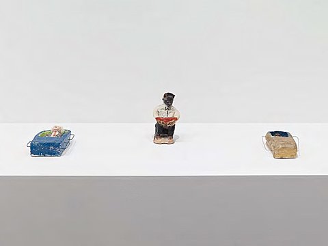 Three small ceramic figures on a white surface.