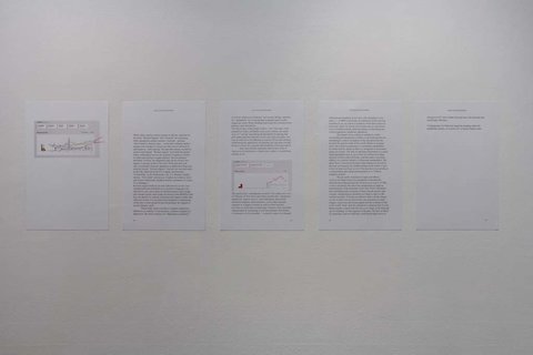 Installation image of an installation in the exhibition featuring five pieces of white paper, with black type face printed on it, although illegible from camera view. 