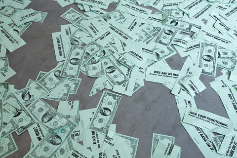 Overhead shot of dollar bills scattered across the floor.