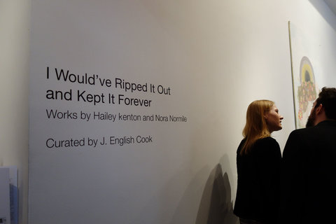 Image of vinyl wall text stating "I WOULD'VE RIPPED IT OUT AND KEPT IT FOREVER" underneath in small text, "WORKS BY HALEY KENTON AND NORA NORMILE. Below this, it states, "CURATED BY J. ENGLISH COOK."
