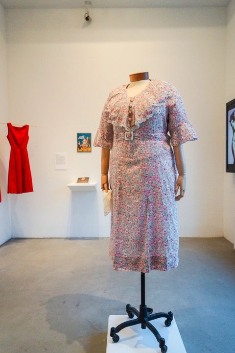 Installation view of the exhibition featuring one pink women's suit. 