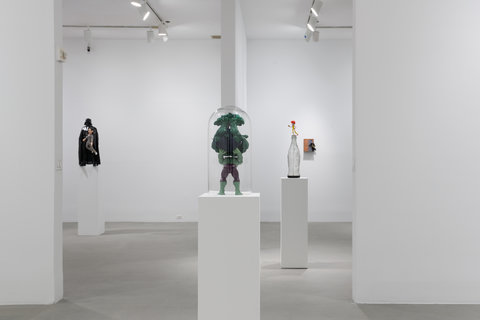 Installation image of three sculptures in the exhibition scattered around the room on three white pedestals. 