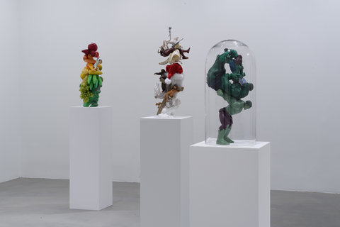 Installation image of three sculptures in the exhibition scattered around the room on three white pedestals. 