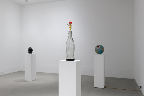 Installation image of three pedestals with sculptures scattered across the room. 