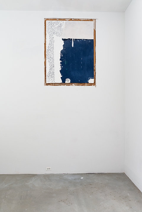 A section of wall is exposed to reveal a drawing in blue pigment. 