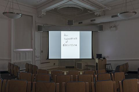 A projection of the hand-written text "the supernova of narcissism."