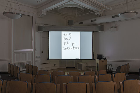 A projection of the hand-written text "Would pain help you concentrate?"